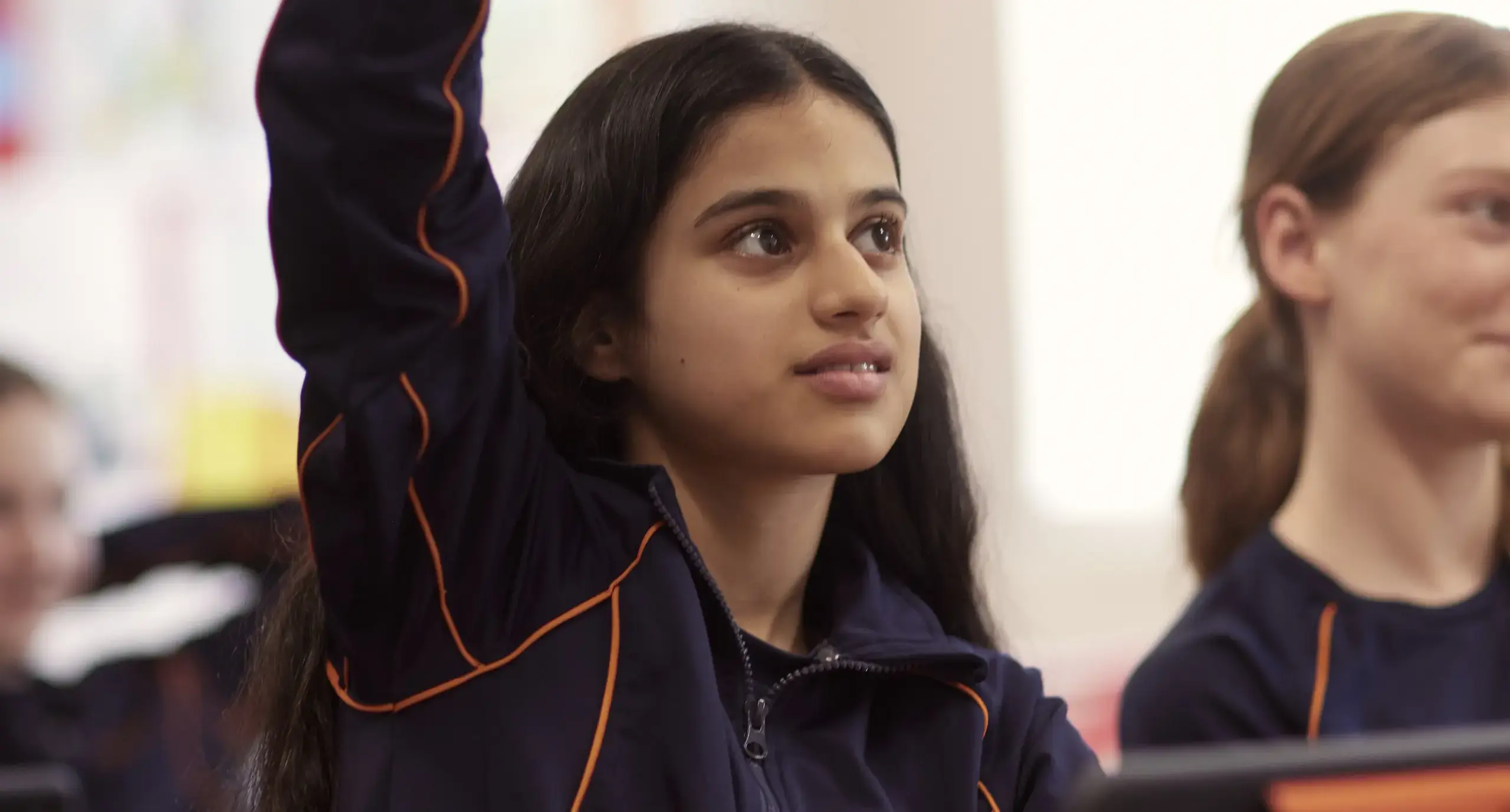 Student putting her hand up in a lesson