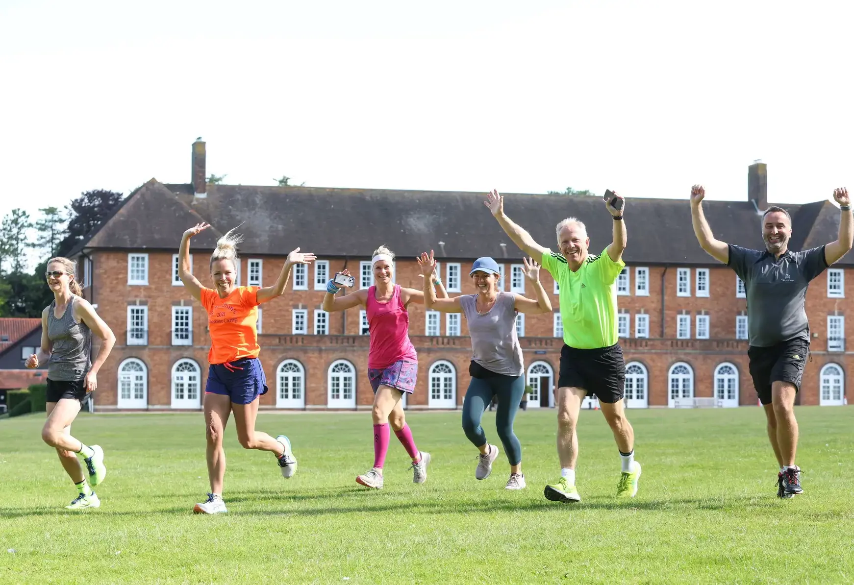 Staff running on a pitch with their arms in the air